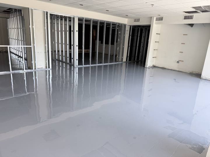 Large open room with a fresh glossy gray floor coating