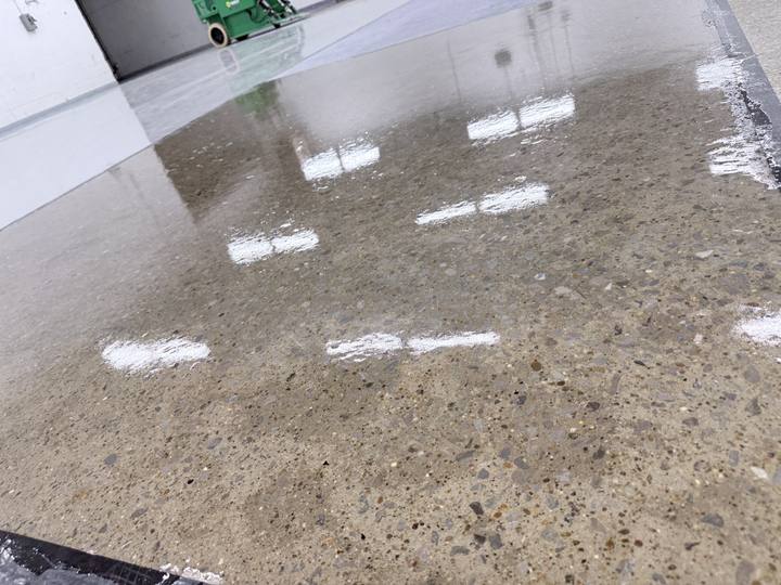 Glossy finished concrete floor reflecting ceiling lights