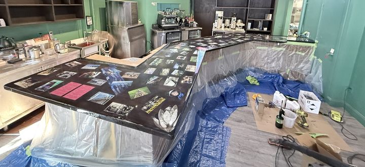 L-shaped bar top with photos sealed under a glossy clear epoxy coat