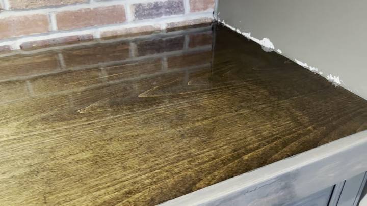 Wood counter with a glossy clear epoxy coat against a brick wall