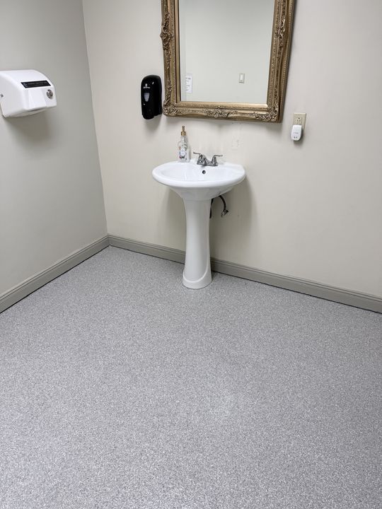 Restroom with a light gray flake epoxy floor and pedestal sink