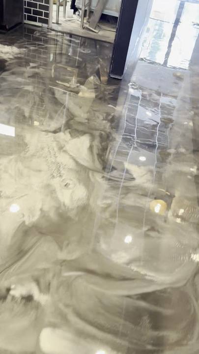 High-gloss silver metallic epoxy floor with light reflections