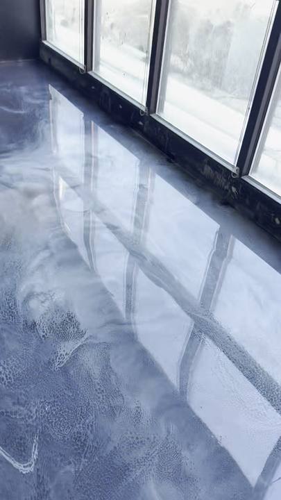 Metallic epoxy floor reflecting a row of windows