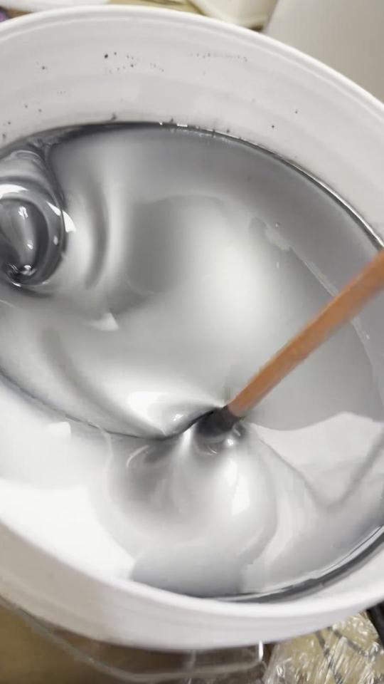 Silver metallic epoxy being mixed in a bucket